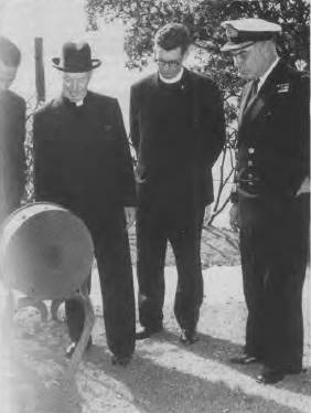 An early member of the Society, His Eminence Cardinal Norman Gilroy, examines the engine telegraph of HMAS FANTOME which is now on display in the Garden Island Museum. L to R: Mr Lew Lind, Cardinal Gilroy, the Cardinal's Secretary and Commodore B .W. Mussared, RAN.