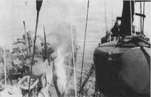 Warramunga's fire hoses playing onto the red hot ship's side, where the 3 inch magazine was located, under their gun mounting.