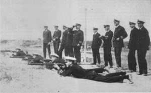 The RANR Officers' Riffle Team on the firing point at the Port Adelaide Rifle Range at which they won the Crane Shield in 1927. The Sub-Lieutenant nearest the camem is Jack Netherton and, next to him, Sam Benson. Lieutenant Jarrett in charge of the firing point with the DNO, Commander A.J. Loudon-Shand, RAN, standing in rear.